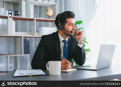Male call center operator or telesales representative siting at his office desk wearing headset and engaged in conversation with client providing customer service support or making a sale. fervent. Male call center operator or telesales agent working on his desk. fervent