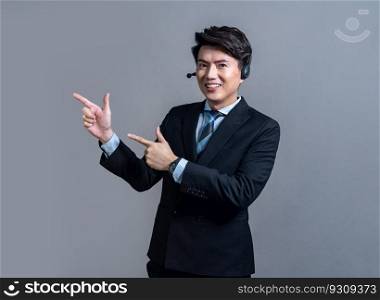 Male call center operator wearing headset and formal suit standing confidently with finger pointing up gesture for product advertisement or HR recruitment on isolated background. Jubilant. Male call center operator wearing headset making finger pointing. Jubilant