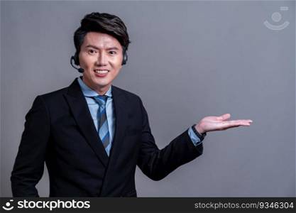 Male call center operator wearing headset and formal suit standing confidently with holding hand gesture for product advertisement or HR recruitment on isolated background. Jubilant. Male call center operator wearing headset making hand gesture. Jubilant