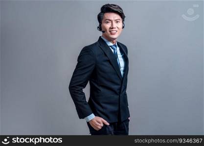 Male call center operator wearing headset and formal suit standing confidently with gesture for product advertisement or HR recruitment on isolated background. Jubilant. Male call center operator wearing headset making advertising gesture. Jubilant