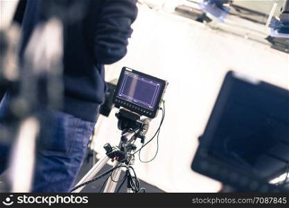 Male cameraman is operating a film camera in a television studio