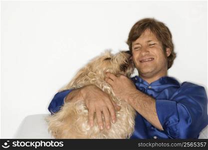 Male Caucasian young adult with fluffy brown dog.