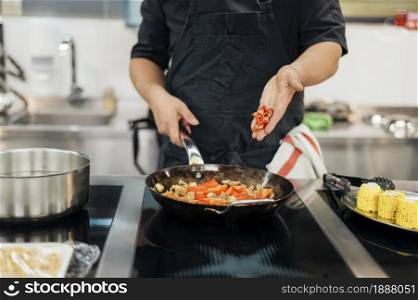 male chef adding chili dish . Resolution and high quality beautiful photo. male chef adding chili dish . High quality and resolution beautiful photo concept