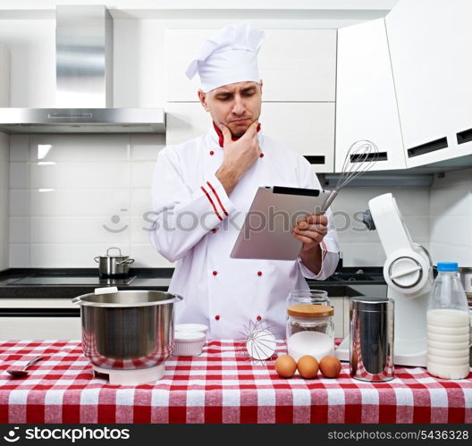 Male chef at kitchen with tablet pc getting ready to cook