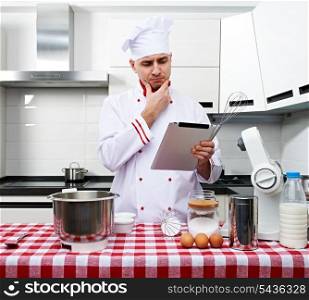 Male chef at kitchen with tablet pc getting ready to cook