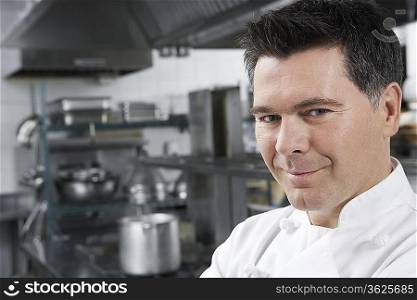 Male chef smiling in kitchen, portrait