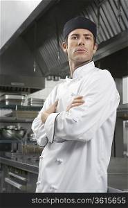 Male chef with arms crossed in kitchen, portrait