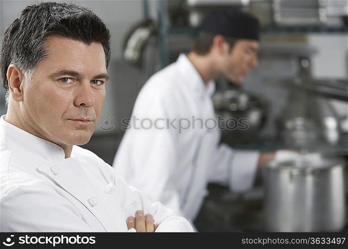 Male chef with colleague in kitchen, portrait