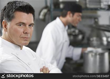 Male chef with colleague in kitchen, portrait