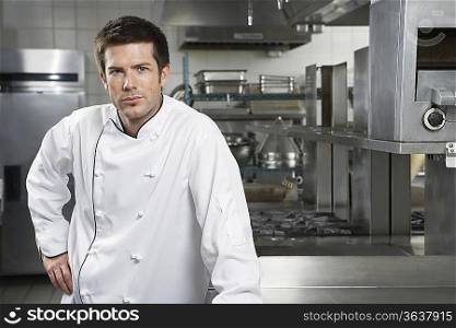 Male chef with hand on hip in kitchen, portrait