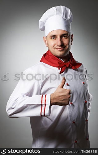 Male chef with thumb up portrait against grey background