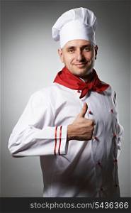 Male chef with thumb up portrait against grey background