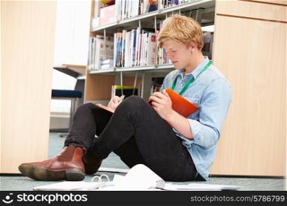 Male College Student Studying In Library