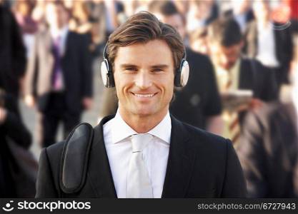Male commuter in crowd wearing headphones