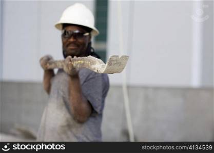 Male construction worker holding a work tool