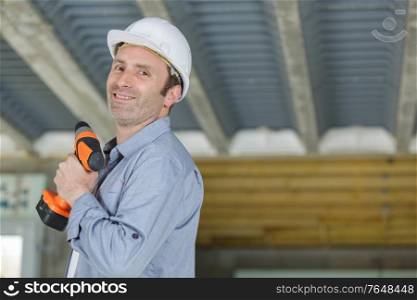 male construction worker holding cordless drill