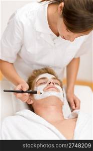 Male cosmetics - facial mask in luxury spa center