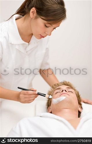Male cosmetics - facial mask in luxury spa center