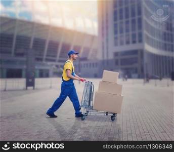 Male courier with trolley in city. Distribution business. Cargo delivery. Empty, clear containers. Logistic and post service