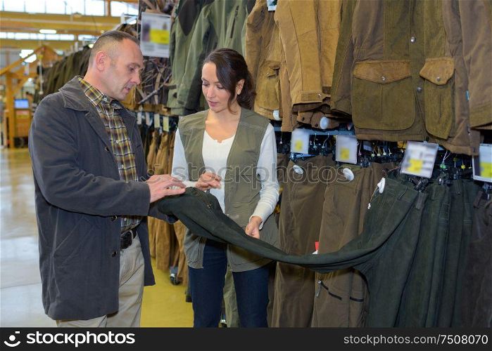 male customer examining trousers in menas cloths store