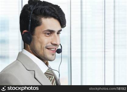 Male customer service representative looking away in office