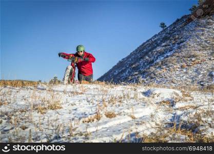 male cyclist riding a fat bike in winter Colorado foothills landscape - Lory State Park