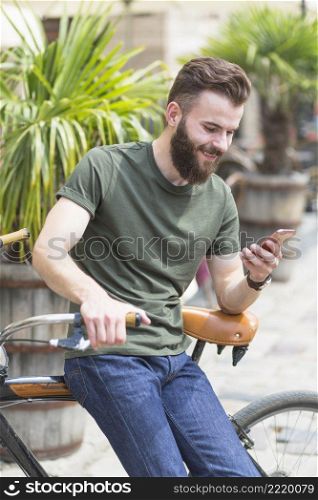 male cyclist sitting bicycle using cellphone