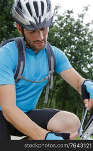 male cyclist tightening nut on bicycle wheel