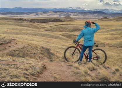 male cyclist with a gravel bike on a single track trail in Colorado foothills in early spring scenery, Soapstone Prairie Natural Area