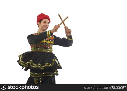 Male dandiya dancer dancing with sticks