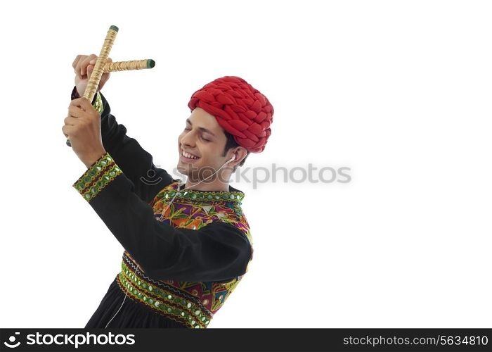 Male dandiya dancer listening to music and dancing