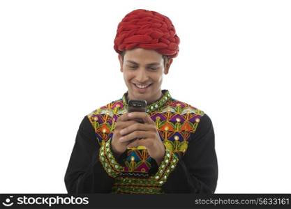 Male dandiya dancer reading an sms