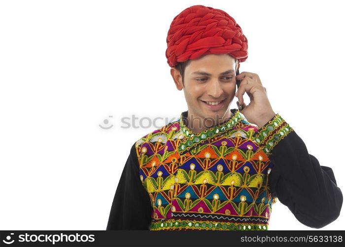 Male dandiya dancer talking on a mobile phone
