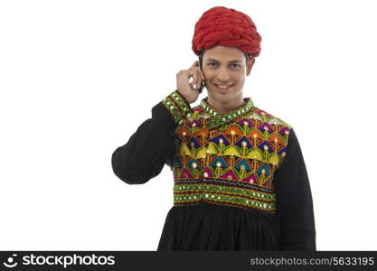 Male dandiya dancer talking on a mobile phone