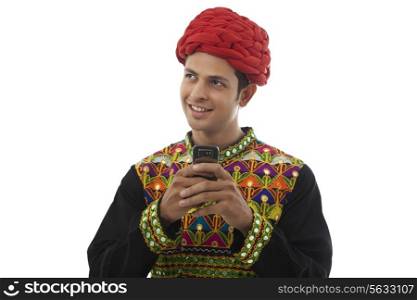 Male dandiya dancer with a mobile phone