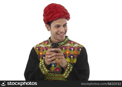Male dandiya dancer with a mobile phone