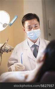 Male Dentist Examining Female Patient