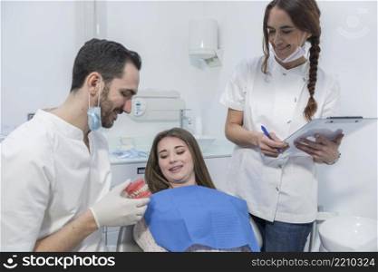 Male dentist show jaw to a little girl