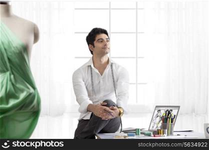 Male designer model in studio looking away
