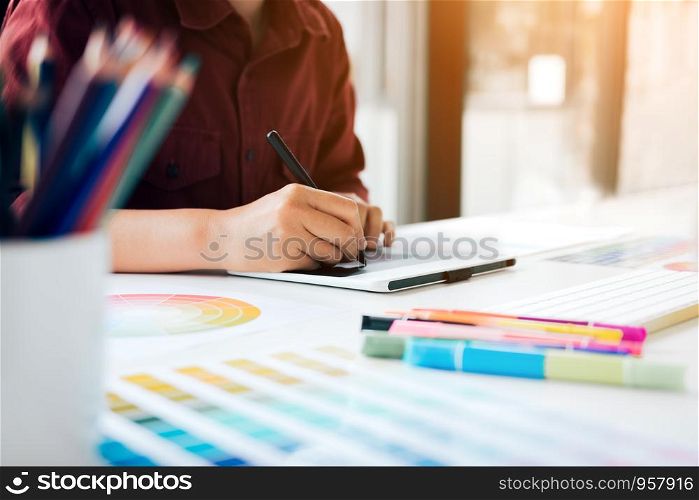 Male designer sitting in the company office and working on digital graphic tablet.