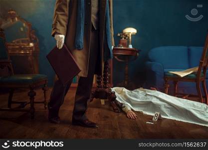 Male detective in coat holds leather folder, victim under the cape at the crime scene, retro style. Criminal investigation, inspector is working on a murder, vintage room interior on background. Detective holds leather folder, crime scene