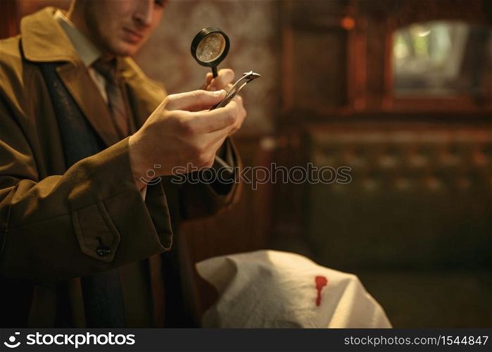 Male detective looks on evidence through magnifying glass at the crime scene, retro style. Criminal investigation, inspector is working on a murder, vintage room interior on background. Detective looks evidence through magnifying glass