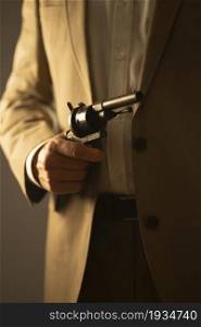 Male detective spy killer holding pistol gun in dramatic novel book cover design color photo.
