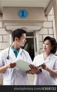 Male doctor and a female doctor discussing a report