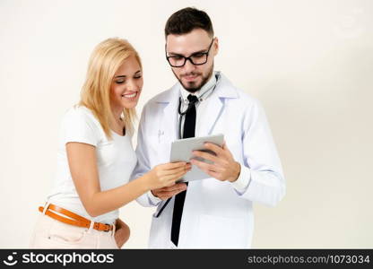 Male doctor and female patient looks at tablet computer for health data record. Healthcare and medical service.