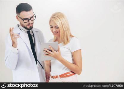 Male doctor and female patient looks at tablet computer for health data record. Healthcare and medical service.. Male Doctor and Female Patient in Hospital.