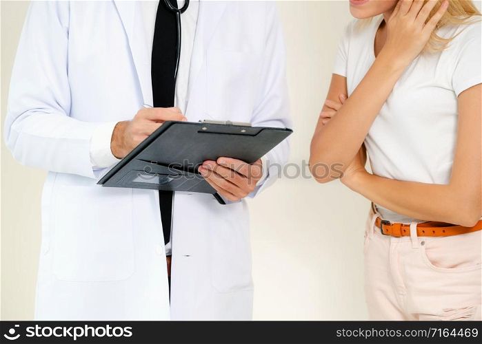 Male doctor and female patient with documents of patients health record are having conversation in hospital. Healthcare and medical service.. Male Doctor and Female Patient in Hospital Office