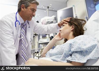 Male Doctor Examining Female Patient In Emergency Room