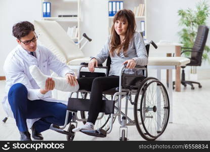 Male doctor examining female patient on wheelchair