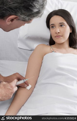 Male doctor giving an injection to a female patient